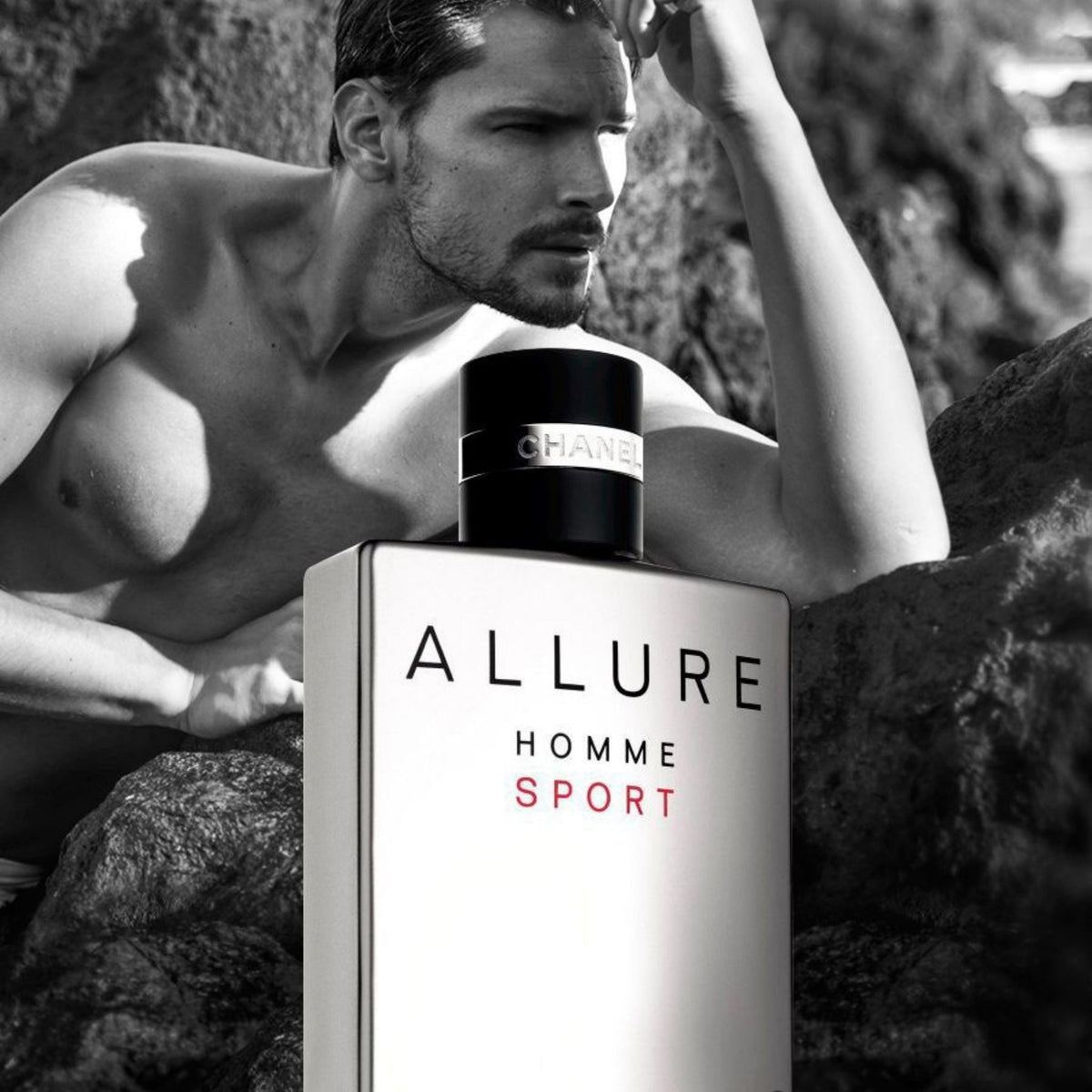 Refect Beauty Chanel Allure Homme Sport Eau de Toilette bottle next to a shirtless man on a rocky beach in black and white