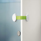 Refect Beauty Chicco child safety cupboard lock with white plastic mounts and an adjustable green strap on a cabinet