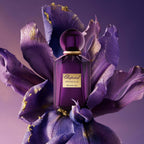 Refect Beauty Chopard Imperiale Iris Malika perfume bottle resting on a large purple iris flower with gold accents