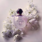 Refect Beauty Christian Dior Pure Poison Eau de Parfum bottle surrounded by delicate white flowers on a light surface.