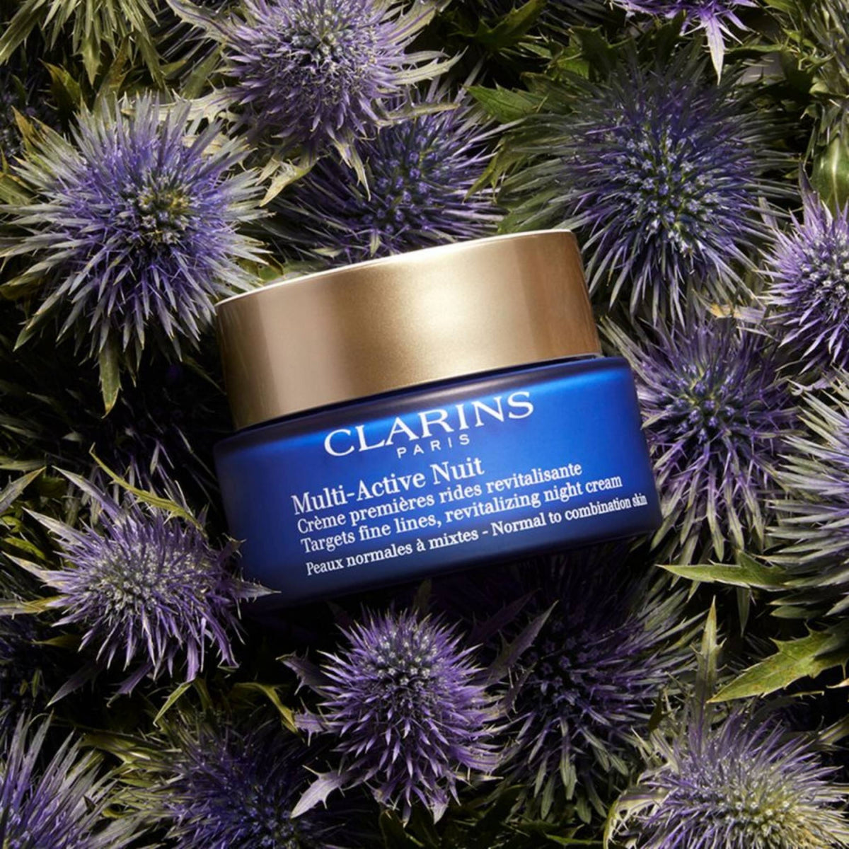 Refect Beauty Clarins Multi-Active Night Cream jar for normal to combination skin nestled among purple thistle flowers.