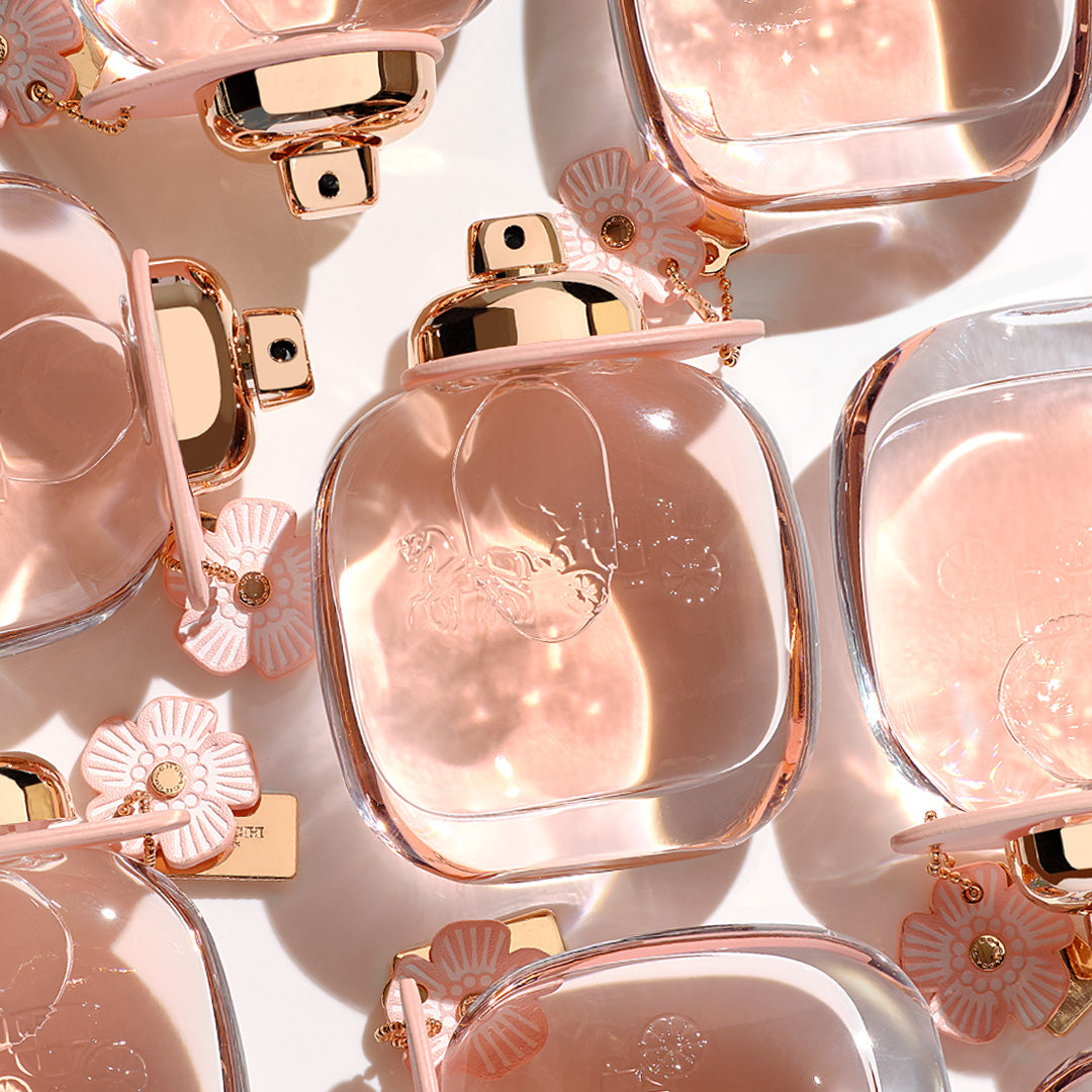 Refect Beauty Coach Floral Eau de Parfum bottles with pink flower charms and gold accents on a white background