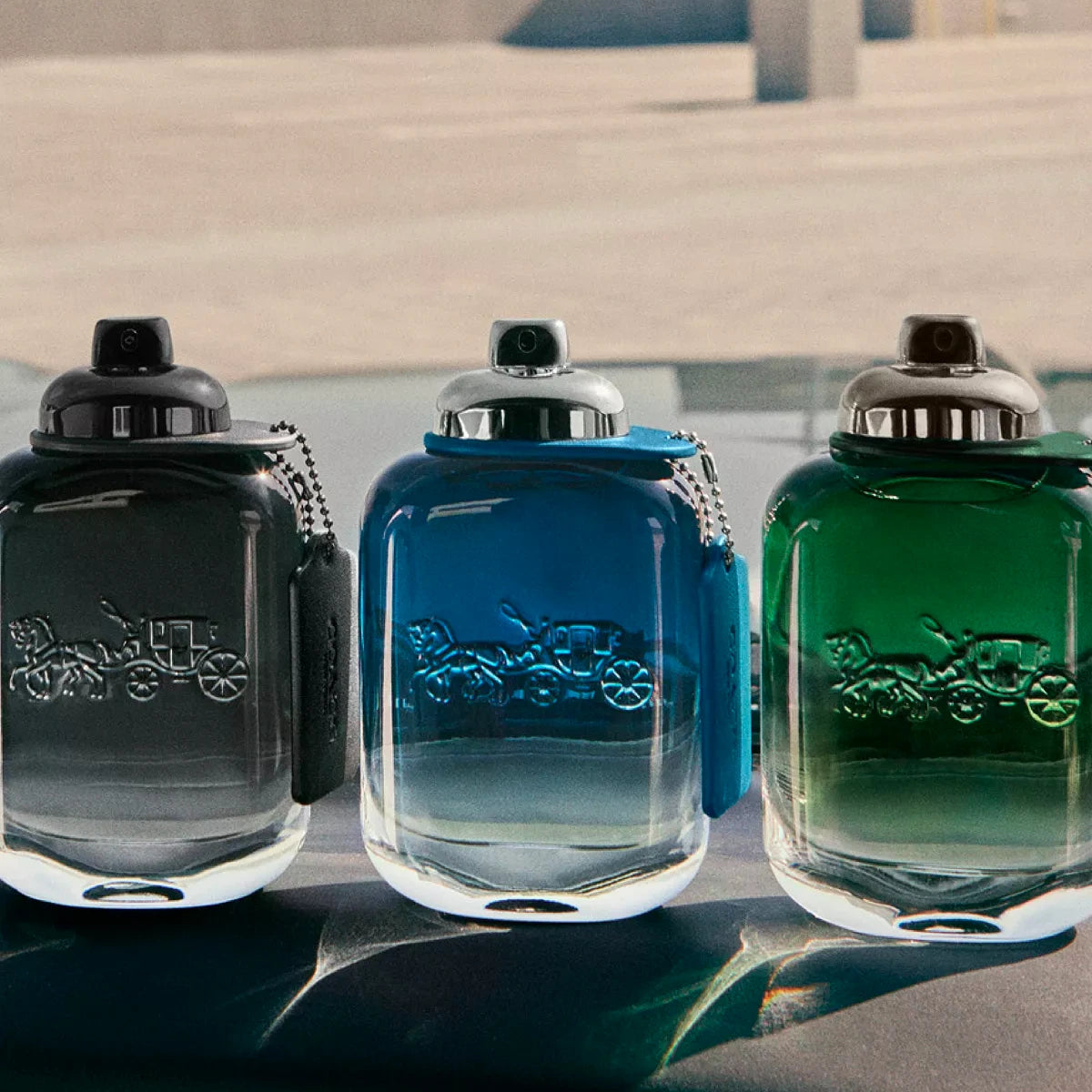 Refect Beauty Coach men's fragrance collection featuring three glass bottles in black, blue, and green gradients.