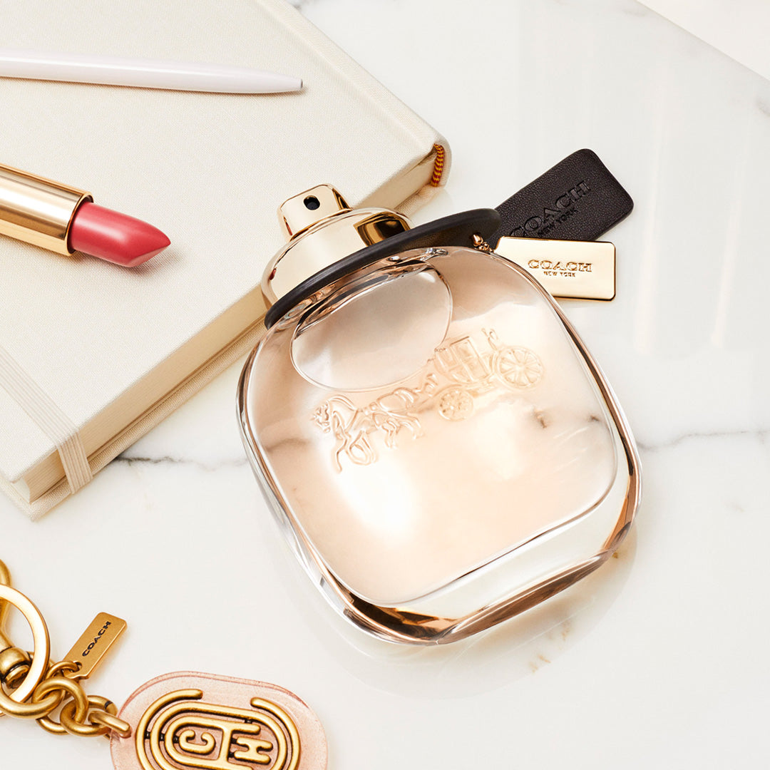 Refect Beauty Coach for Women Eau de Parfum bottle with a gold horse and carriage logo on a marble surface.