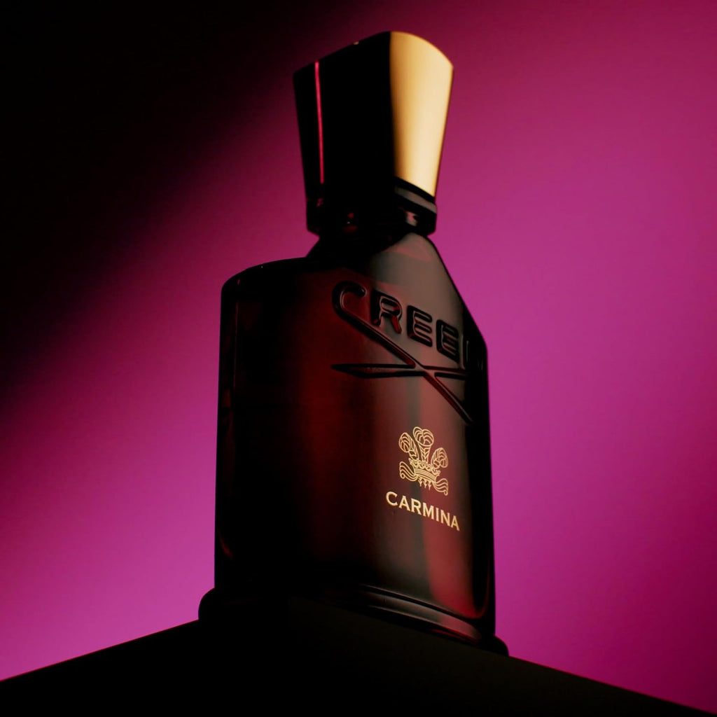 Refect Beauty Creed Carmina Eau de Parfum bottle with gold cap against a vibrant magenta background