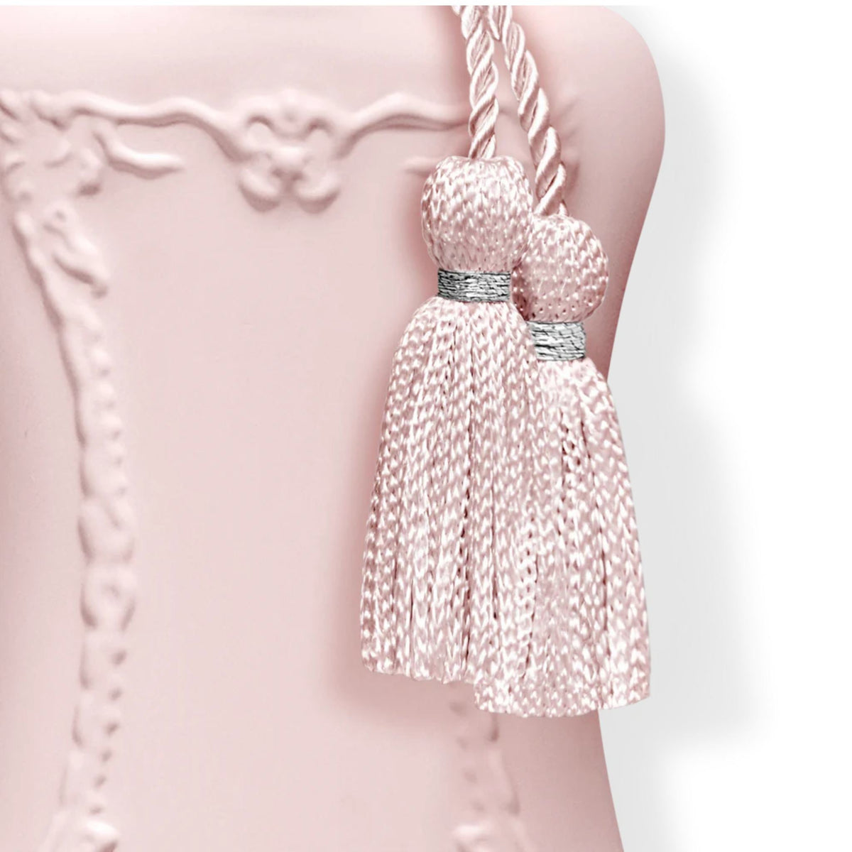 Refect Beauty Parfums de Marly Delina perfume bottle detail featuring a soft pink finish and decorative silk tassels.