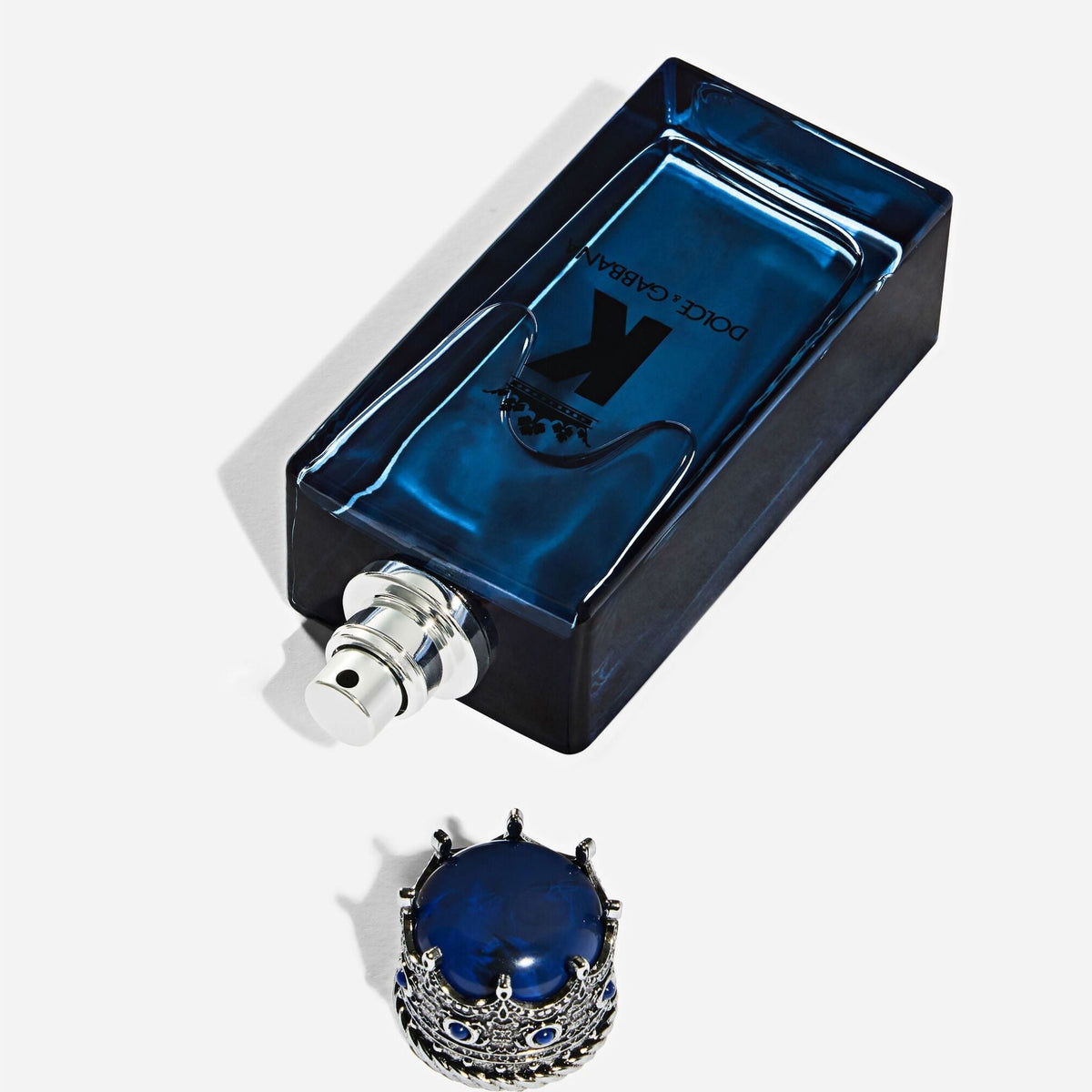 Refect Beauty Dolce & Gabbana K Eau de Parfum bottle in deep blue glass with a silver crown cap on a white background