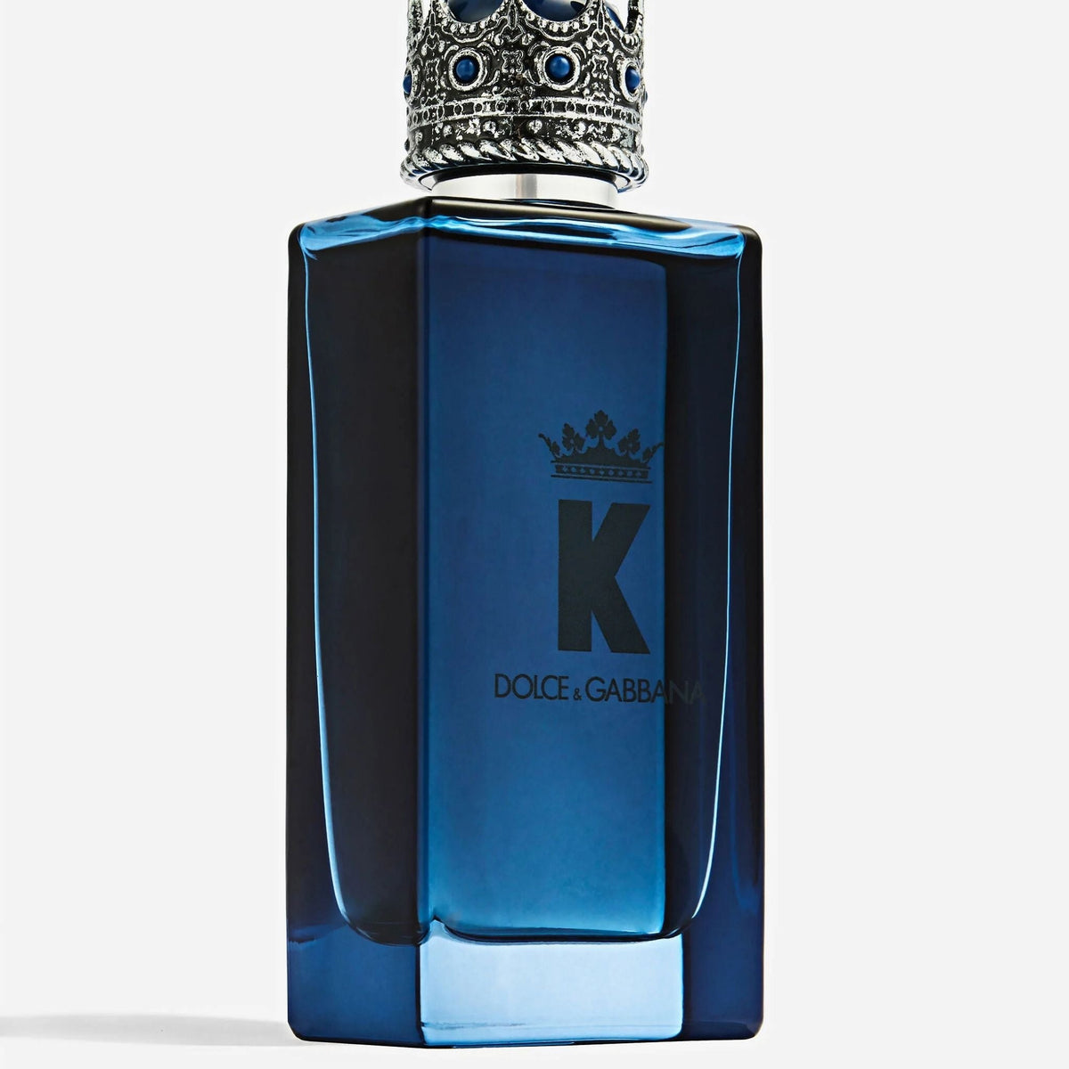 Refect Beauty Dolce & Gabbana K Eau de Parfum in a deep blue glass bottle with a silver crown cap and blue accents.