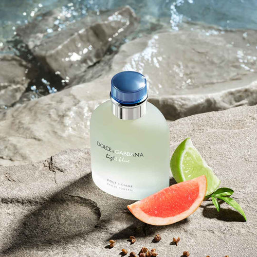 Refect Beauty Dolce & Gabbana Light Blue Pour Homme fragrance bottle on a stone surface with lime and grapefruit slices