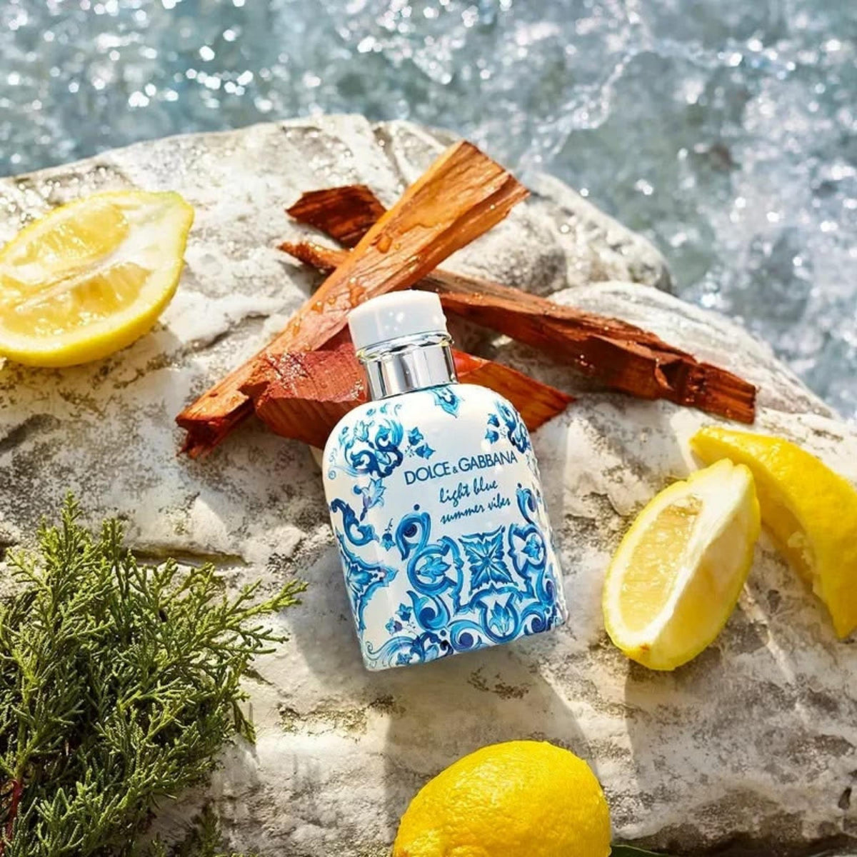 Refect Beauty Dolce & Gabbana Light Blue Summer Vibes EDT bottle on a rock with fresh lemons and cedarwood
