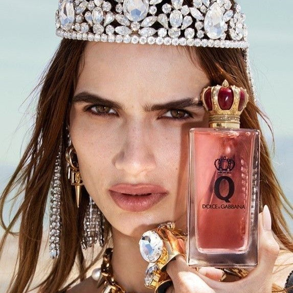 Refect Beauty model wearing a crystal crown holding a bottle of Dolce & Gabbana Q Eau de Parfum with a crown cap