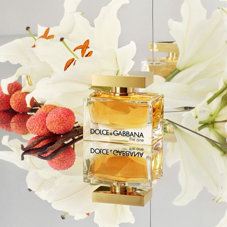 Refect Beauty Dolce & Gabbana The One Eau de Parfum bottle surrounded by white lilies, litchi fruit, and vanilla beans.