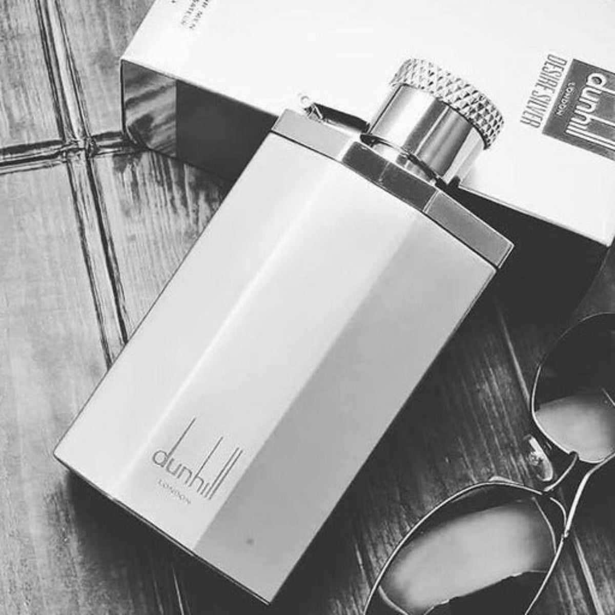Refect Beauty Dunhill Desire Silver eau de toilette bottle with metallic finish next to its box and sunglasses