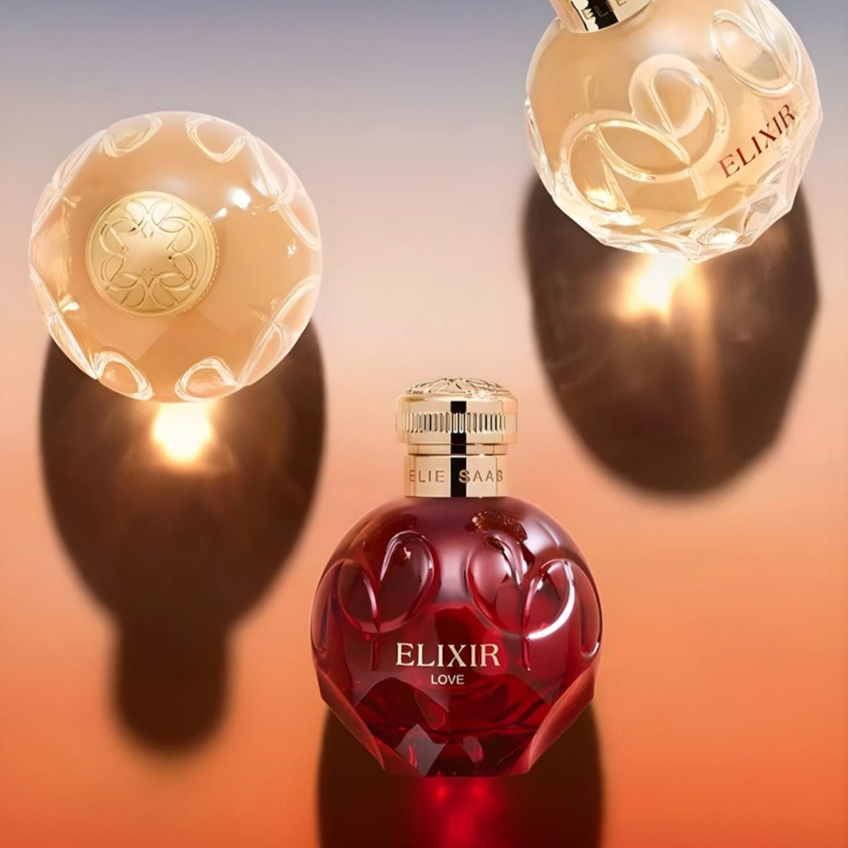Refect Beauty Elie Saab Elixir Love perfume bottle in deep red glass with gold cap on a reflective gradient surface
