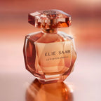 Refect Beauty Elie Saab Le Parfum Absolu glass perfume bottle with warm amber liquid against a glowing orange background