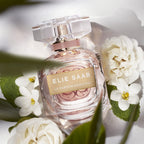 Refect Beauty Elie Saab Le Parfum Essentiel perfume bottle surrounded by white gardenia flowers and green leaves