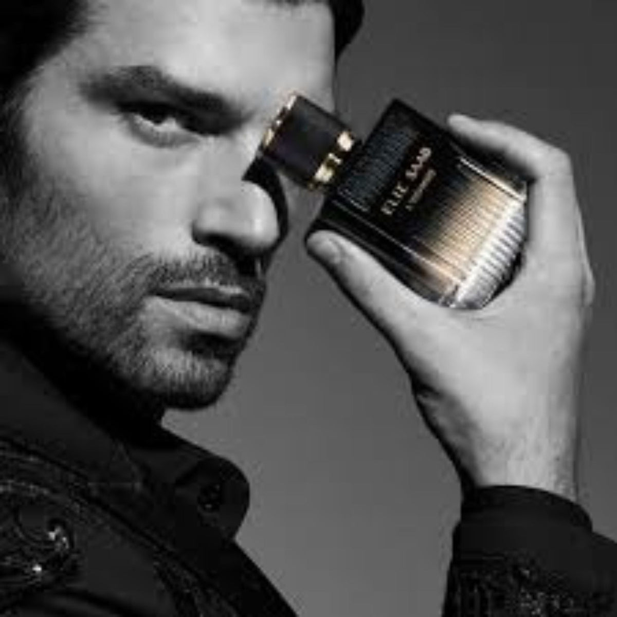 Refect Beauty Elie Saab L'Homme Eau de Parfum bottle held by a man in a sophisticated black suit