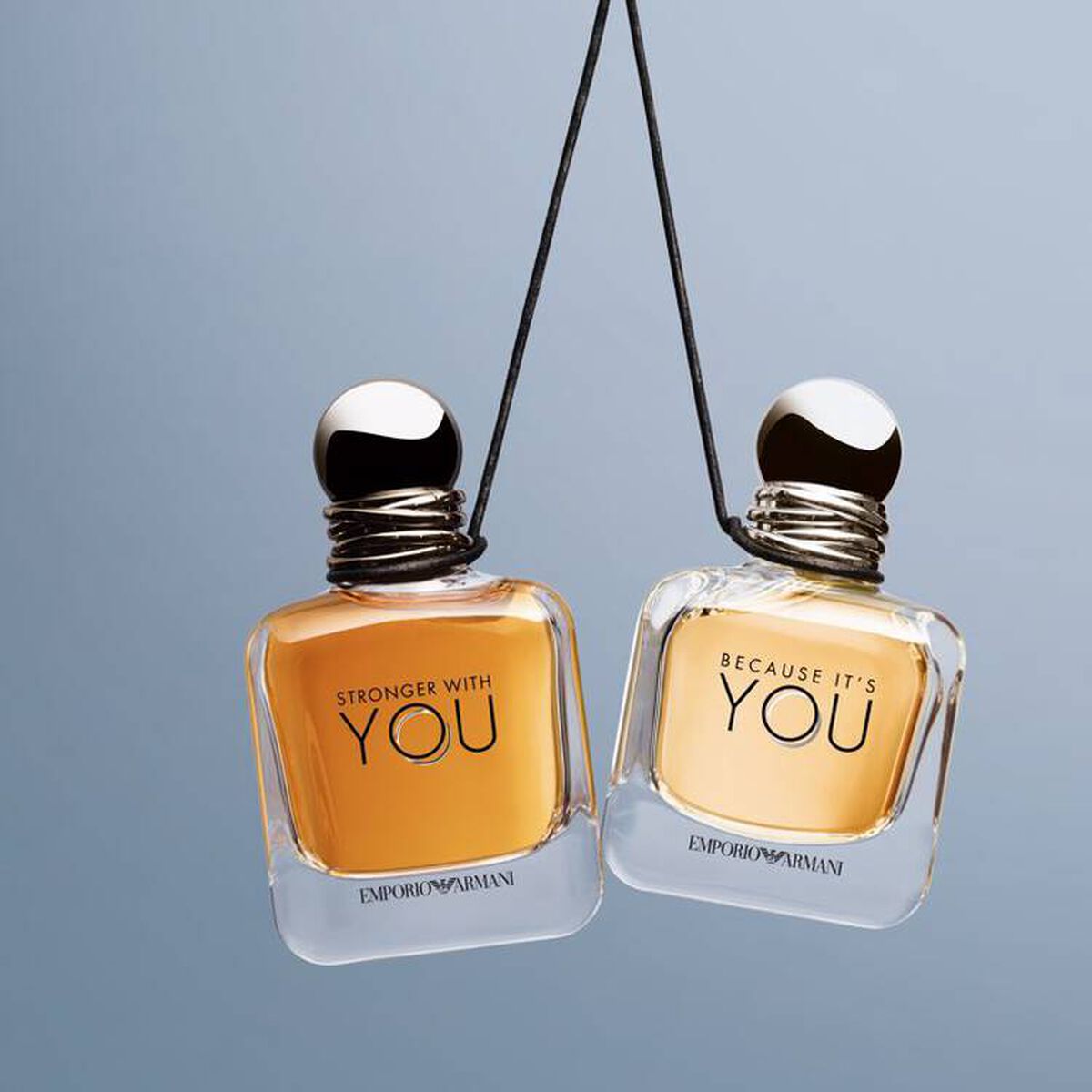 Refect Beauty Emporio Armani Because It's You and Stronger With You perfume bottles hanging against a blue background