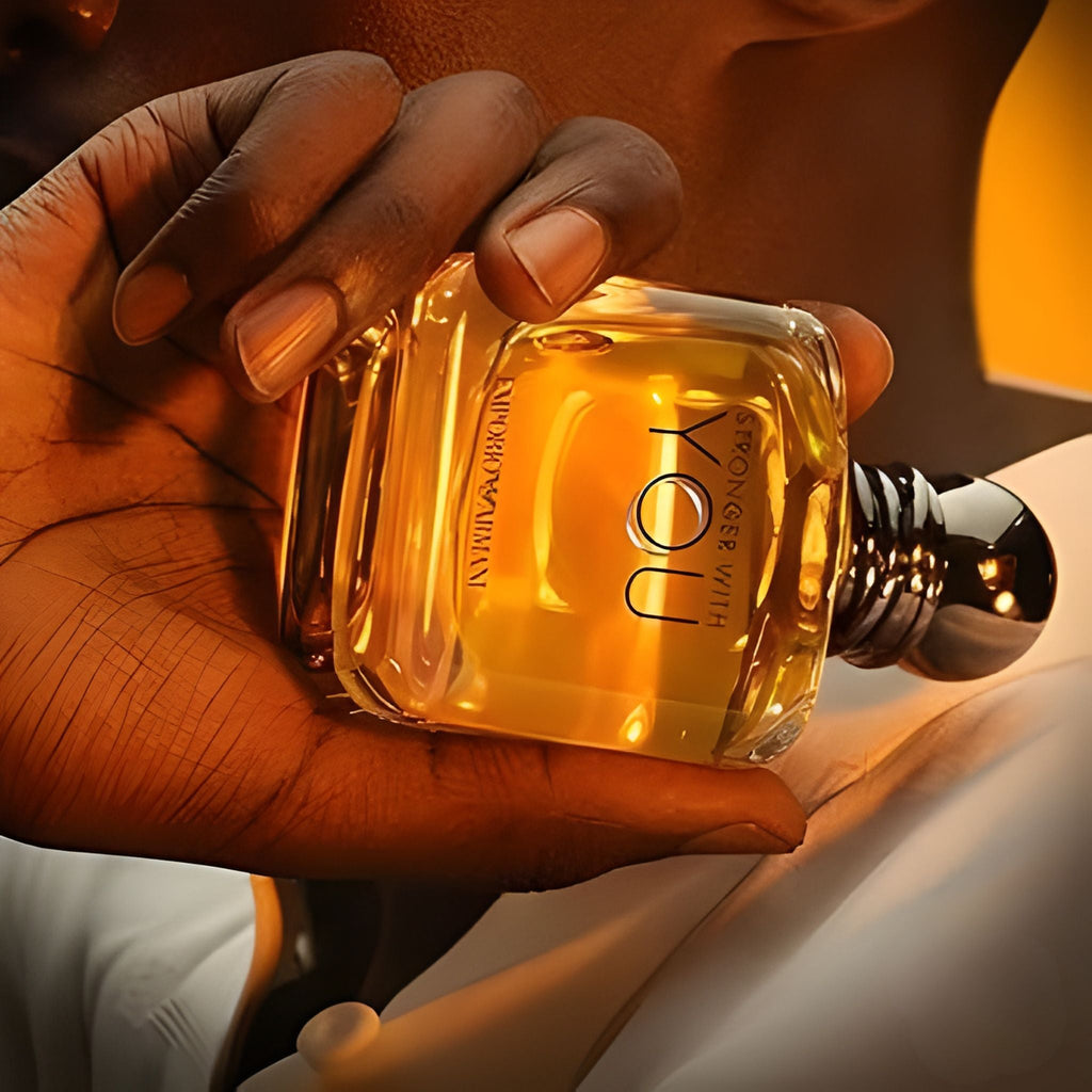 Refect Beauty Emporio Armani Stronger With You eau de toilette bottle held in a hand against a warm golden background