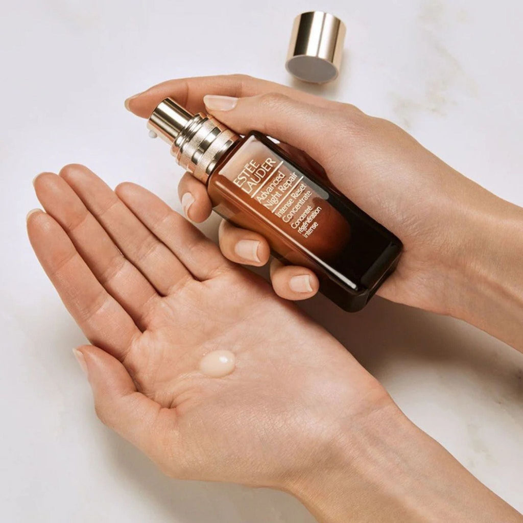 Refect Beauty Estée Lauder Advanced Night Repair serum bottle held in hands with a drop of concentrate on the palm