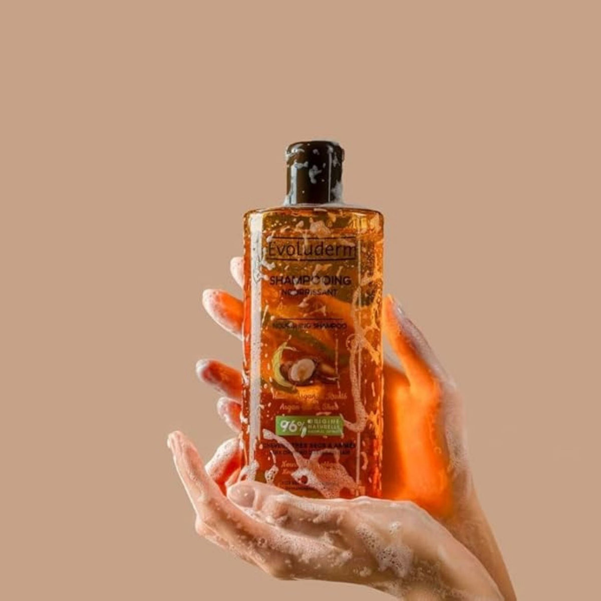 Refect Beauty Evoluderm Argan Divin nourishing shampoo bottle held in soapy hands for dry and damaged hair