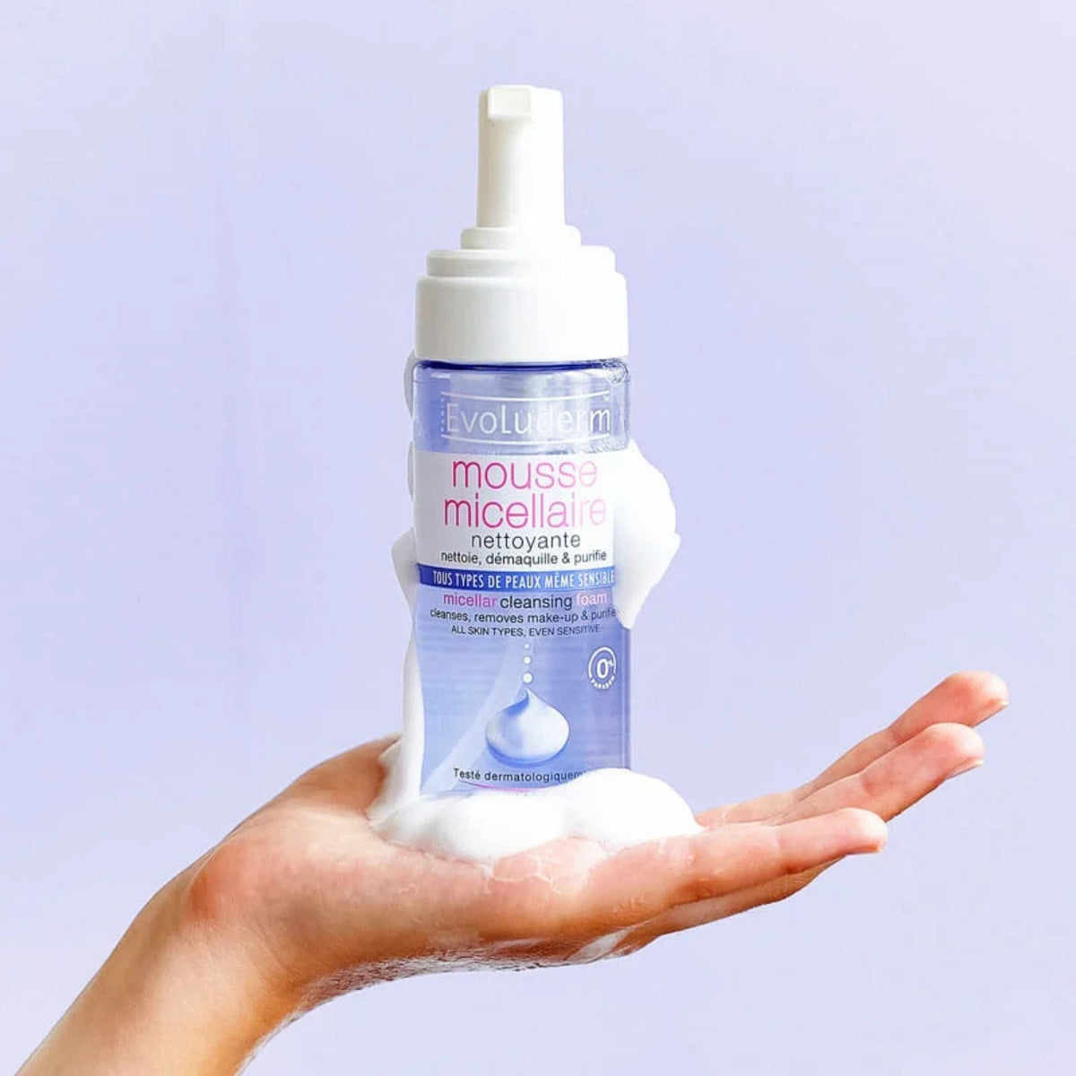 Refect Beauty Evoluderm Micellar Cleansing Foam in a pump bottle held in a hand with white cleansing foam on top.