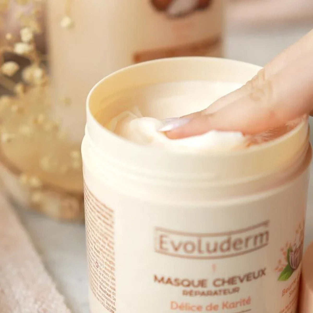 Refect Beauty Evoluderm Shea Butter hair mask in a beige jar with a finger scooping out the creamy product