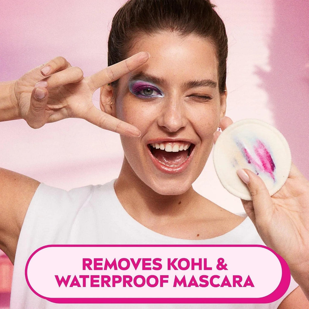 Refect Beauty model winking while holding a cotton pad with removed makeup, showing effective eye cleansing.