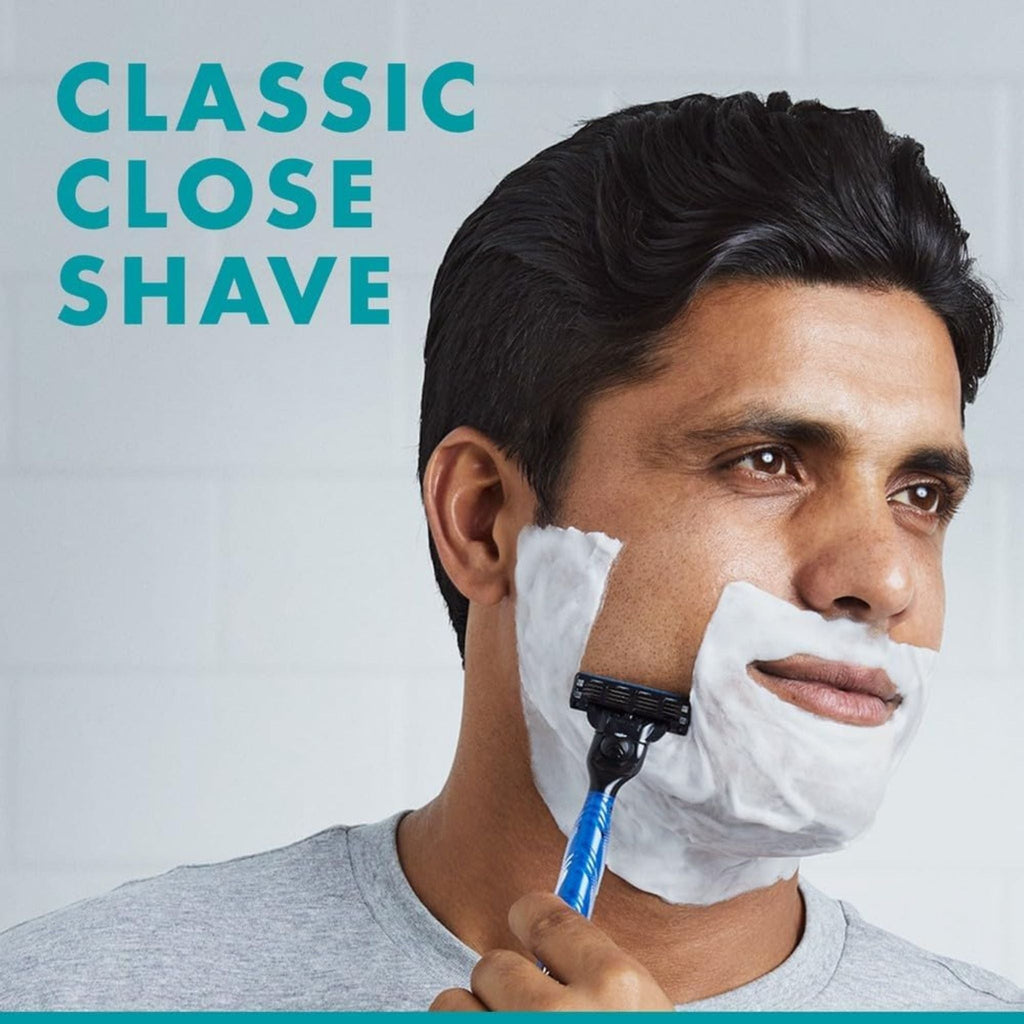 Refect Beauty man shaving his face with a blue Gillette Mach 3 razor covered in white shaving foam