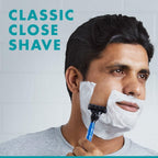 Refect Beauty man shaving his face with a blue Gillette Mach 3 razor covered in white shaving foam
