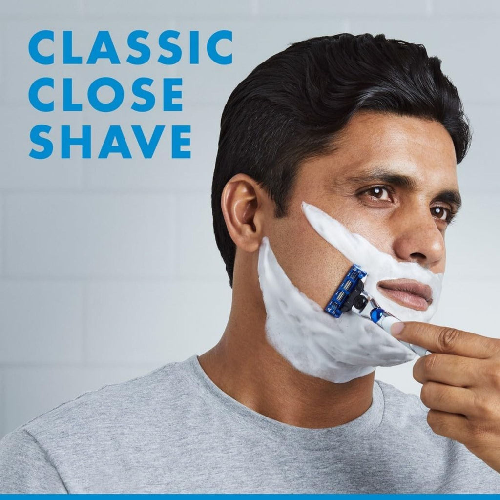 Refect Beauty Gillette Mach3 Turbo 3D razor shaving a man's face covered in white foam for a smooth, close shave.