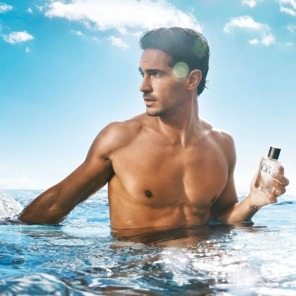 Refect Beauty Giorgio Armani Acqua Di Gio fragrance bottle held by a man in the ocean under a bright blue sky