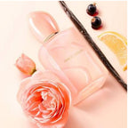 Refect Beauty Giorgio Armani Sì Nude Bloom perfume bottle surrounded by fresh roses, vanilla bean, and citrus slices.