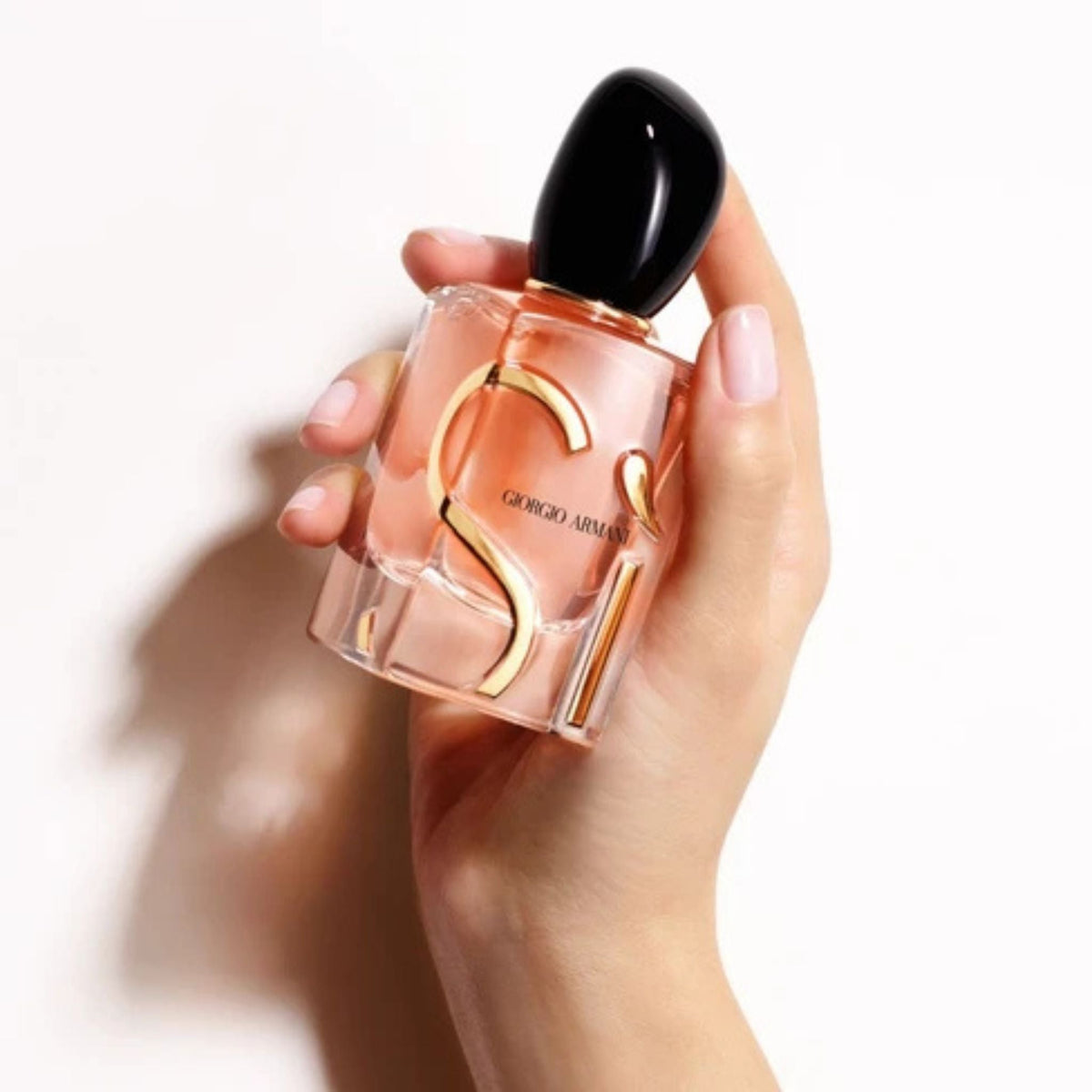 Refect Beauty Giorgio Armani Si Eau de Parfum held in a hand, featuring a glass bottle with gold lettering and black cap