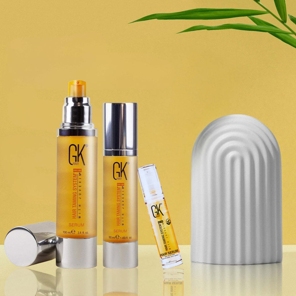 Refect Beauty GK Hair Argan Oil Serum bottles in various sizes with a modern arch decor piece on a yellow background