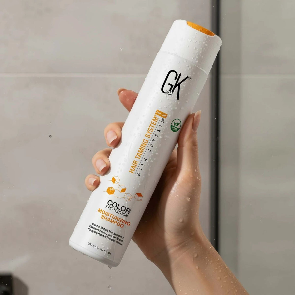 Refect Beauty GK Hair Color Protection Moisturizing Shampoo bottle held in a hand with water droplets