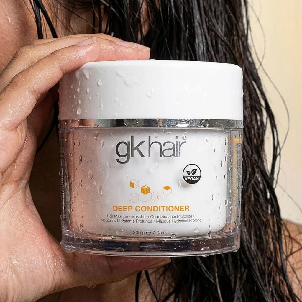 Refect Beauty GK Hair Deep Conditioner mask in a clear jar held by a person with wet hair for intensive treatment.