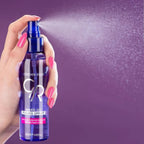 Refect Beauty Golden Rose Makeup Fixing Spray being misted from a blue bottle held by a hand with pink nails