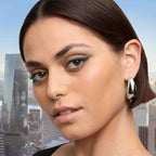 Refect Beauty model wearing Maybelline Sky High green mascara for long, defined lashes against a city skyline backdrop