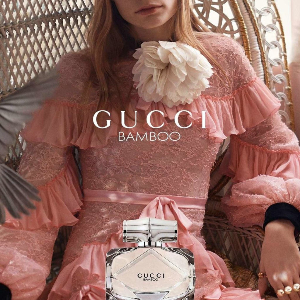 Refect Beauty Gucci Bamboo Eau de Parfum bottle in front of a woman wearing a pink lace dress with a floral accent