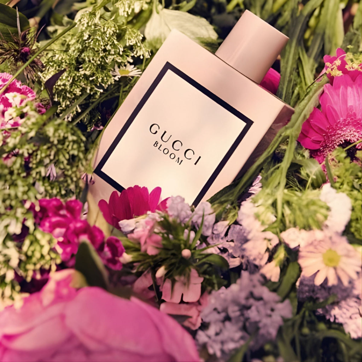 Refect Beauty Gucci Bloom Eau de Parfum bottle nestled among a lush, colorful bouquet of fresh spring flowers.