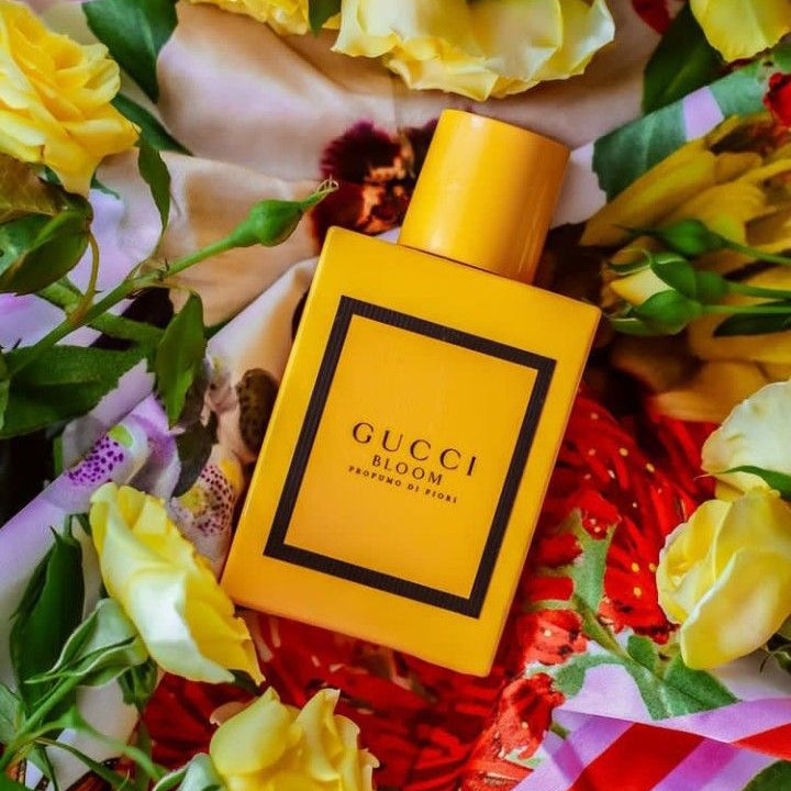 Refect Beauty Gucci Bloom Profumo Di Fiori perfume bottle surrounded by vibrant yellow roses and floral fabric