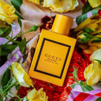Refect Beauty Gucci Bloom Profumo Di Fiori perfume bottle surrounded by vibrant yellow roses and floral fabric