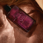 Refect Beauty Gucci Guilty Absolute Pour Femme perfume bottle in deep berry glass resting on soft textured fabric