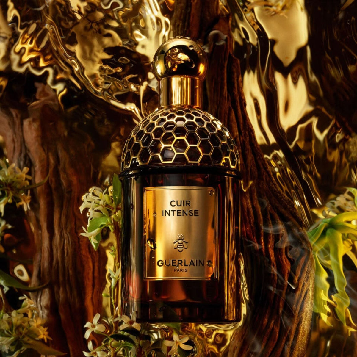 Refect Beauty Guerlain Absolus Allegoria Cuir Intense perfume bottle with gold honeycomb cap against a dark wood background