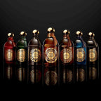Refect Beauty collection of Guerlain luxury perfume bottles with gold ornate labels and caps on a reflective surface