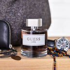 Refect Beauty Guess 1981 for Men Eau De Toilette bottle on a wooden surface with accessories