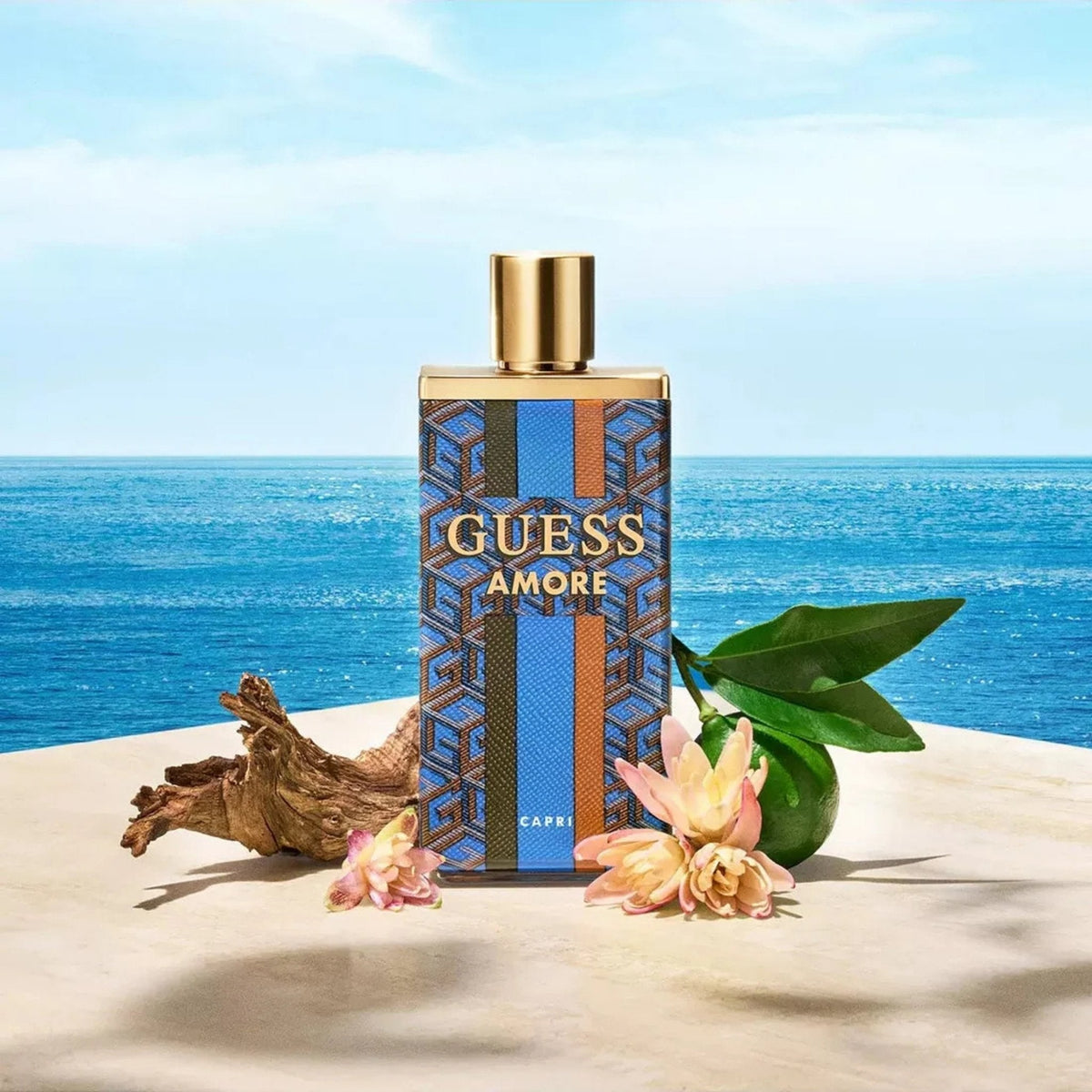 Refect Beauty Guess Amore Capri fragrance bottle with citrus, tropical flowers, and driftwood against a sea backdrop.