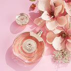 Refect Beauty Guess Bella Vita Rose Eau de Toilette in a round glass bottle with floral accents on a pink background.