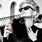 Refect Beauty model wearing sunglasses applying Guess Bella Vita Rose Eau de Toilette on her neck in a chic setting